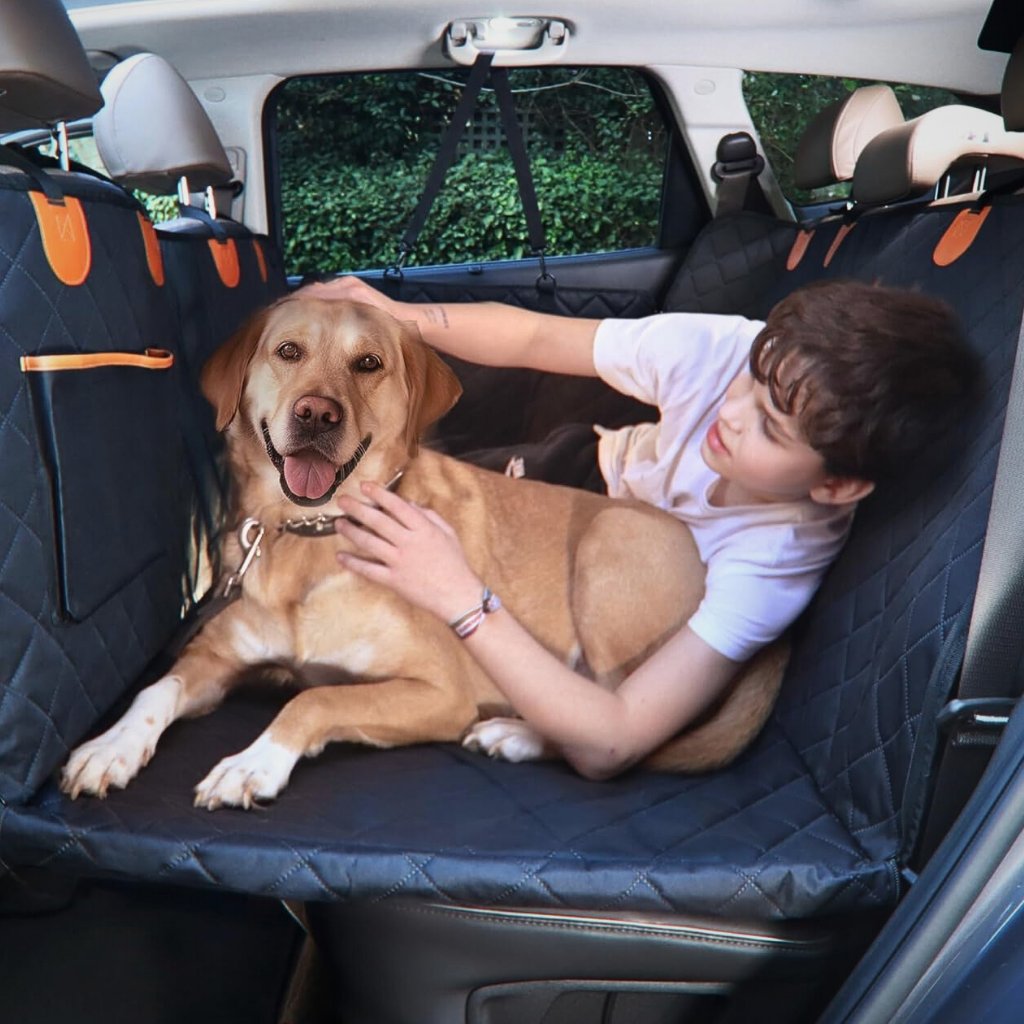 Child and dog comfortably lying on the Pawsely Pup-tastic Car Backseat Cover & Extender, showcasing spacious and secure travel setup.